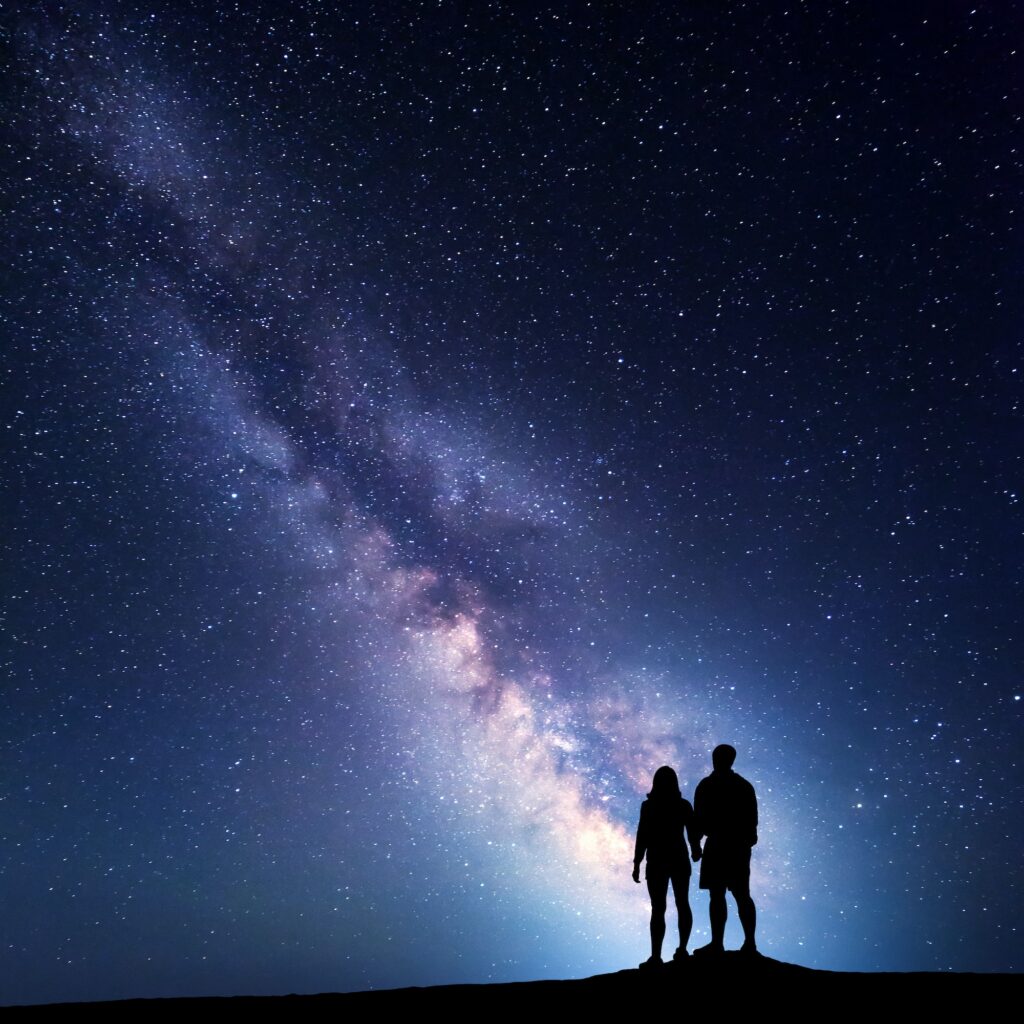 Milky Way with silhouette of people on the mountain