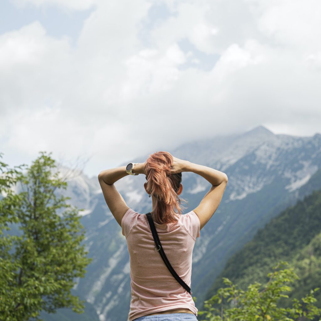 View from behind of a young woman enjoying in beautiful nature